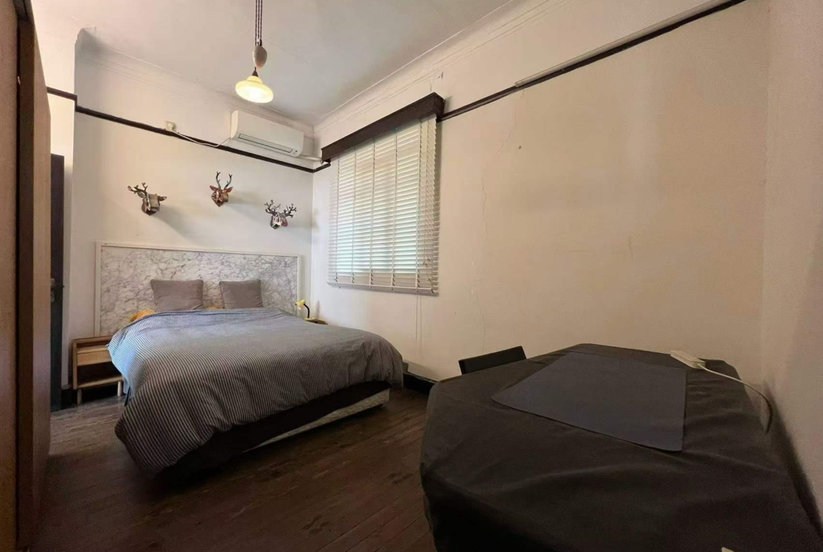 Authentic lane house apartment on Anfu Road with private balcony. 2 beds, 2 living rooms, heritage building, walk to cafes. 18,000 RMB/month.