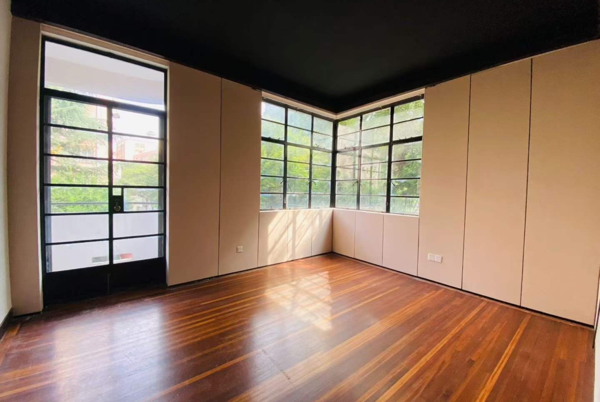 Heritage apartment at 69 North Urumqi Road, built 1935. 180 sqm, 3+1 beds, large balcony, central AC, elevator. Near Jing'an Temple Station. 38,000 RMB/month.