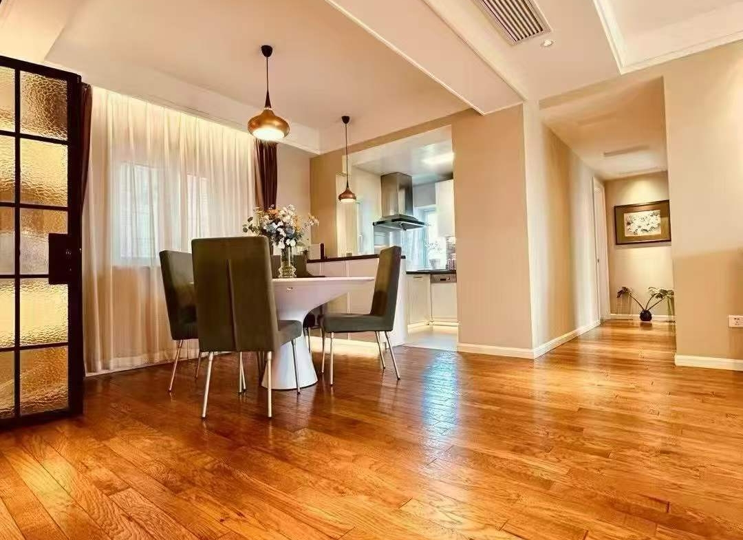 High-floor 2-bed, 2-bath unit at Ambassy Court on Huaihai Road. 114 sqm, Italian designer renovation, imported finishes, underfloor heating, clubhouse. 28,000 RMB/month.