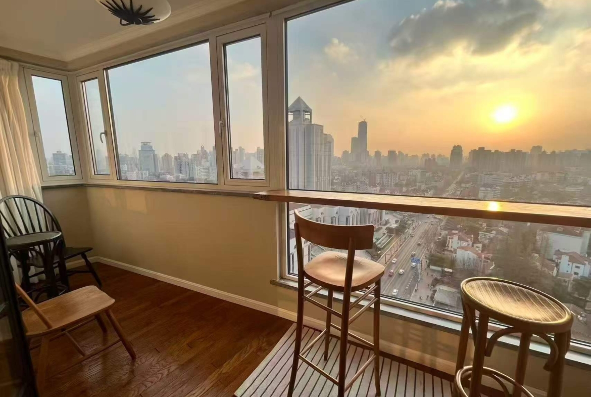 High-floor 2-bed, 2-bath unit at Ambassy Court on Huaihai Road. 114 sqm, Italian designer renovation, imported finishes, underfloor heating, clubhouse. 28,000 RMB/month.