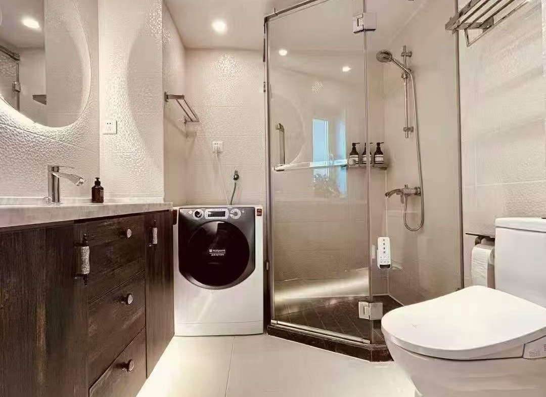 High-floor 2-bed, 2-bath unit at Ambassy Court on Huaihai Road. 114 sqm, Italian designer renovation, imported finishes, underfloor heating, clubhouse. 28,000 RMB/month.
