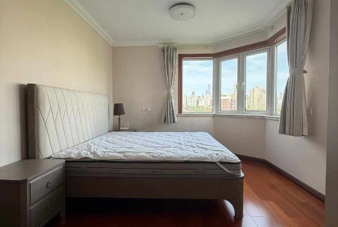 High floor 2-bed unit at Shanghai Grand Plaza on Julu Road. Southeast facing, Lujiazui skyline view, pool view, long-term lease available. 22,000 RMB/month.