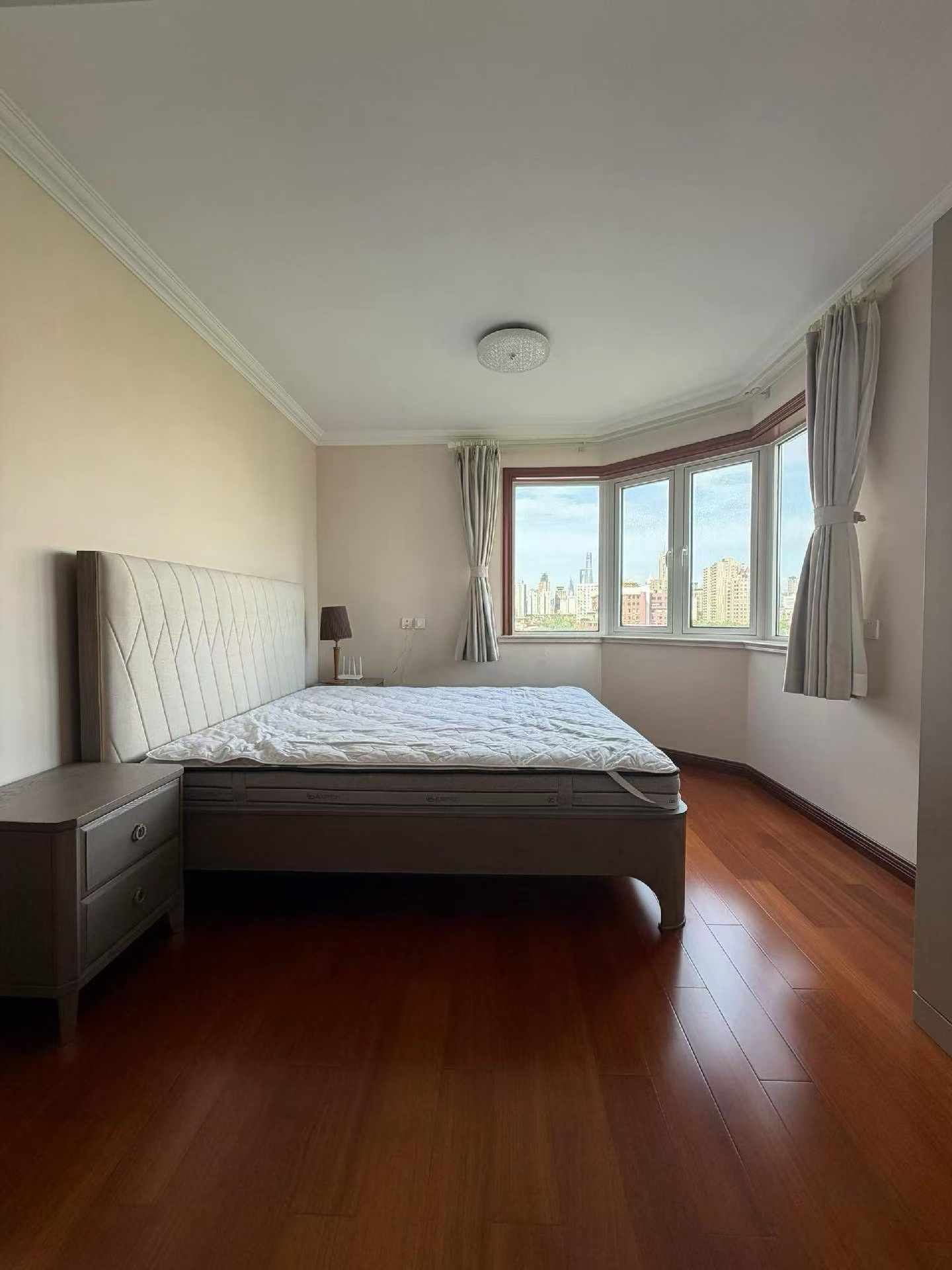 High floor 2-bed unit at Shanghai Grand Plaza on Julu Road. Southeast facing, Lujiazui skyline view, pool view, long-term lease available. 22,000 RMB/month.