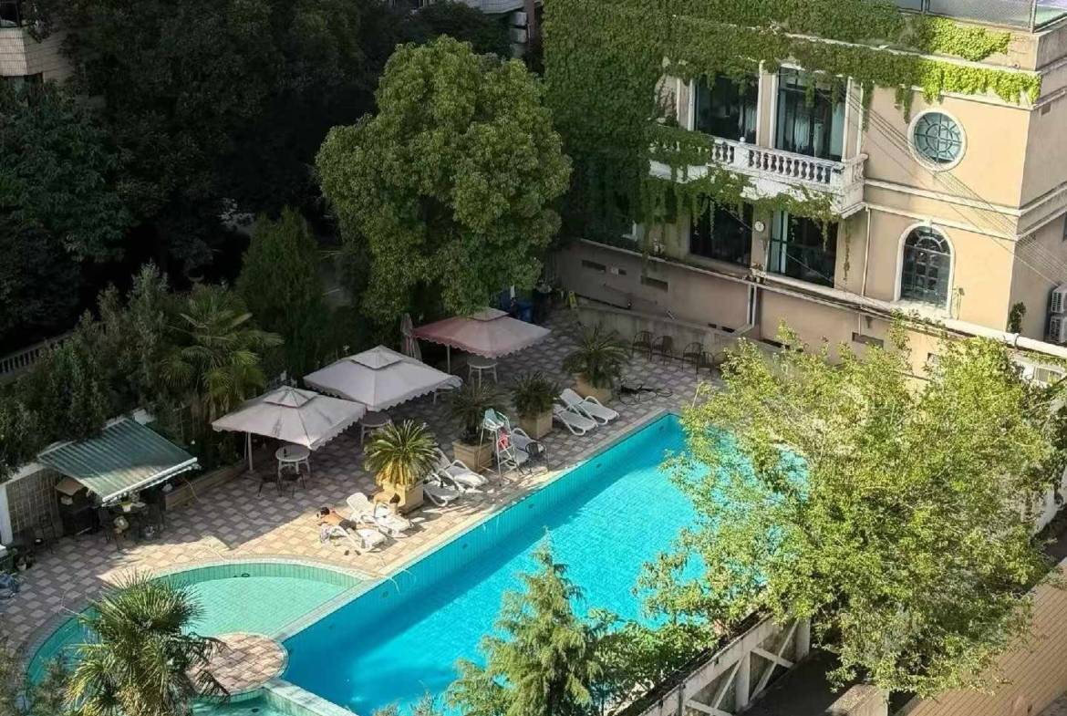 High floor 2-bed unit at Shanghai Grand Plaza on Julu Road. Southeast facing, Lujiazui skyline view, pool view, long-term lease available. 22,000 RMB/month.