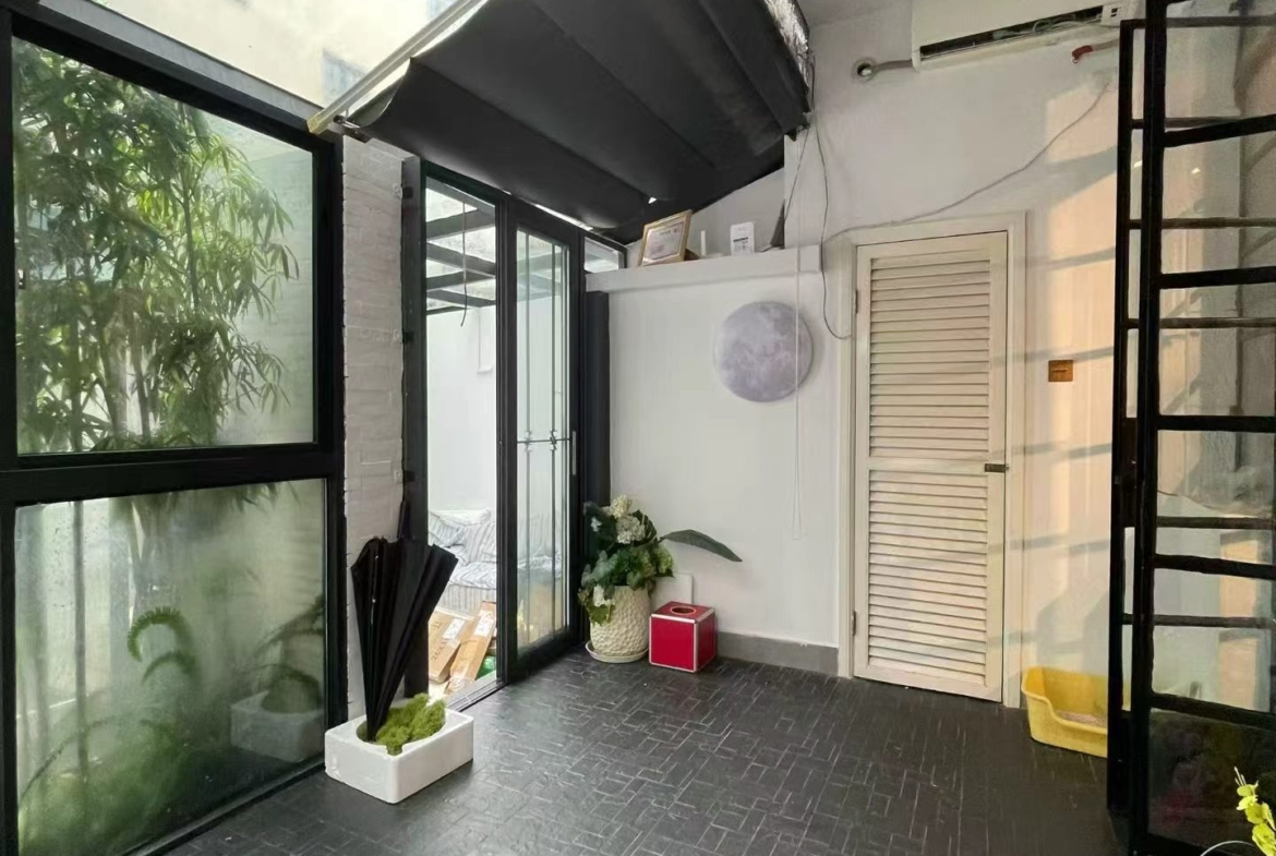 Ground floor studio at Nanhua Xincun on Changle Road. 120 sqm, double south-facing, 30 sqm garden. Ideal for creative studio or office. 22,500 RMB/month.