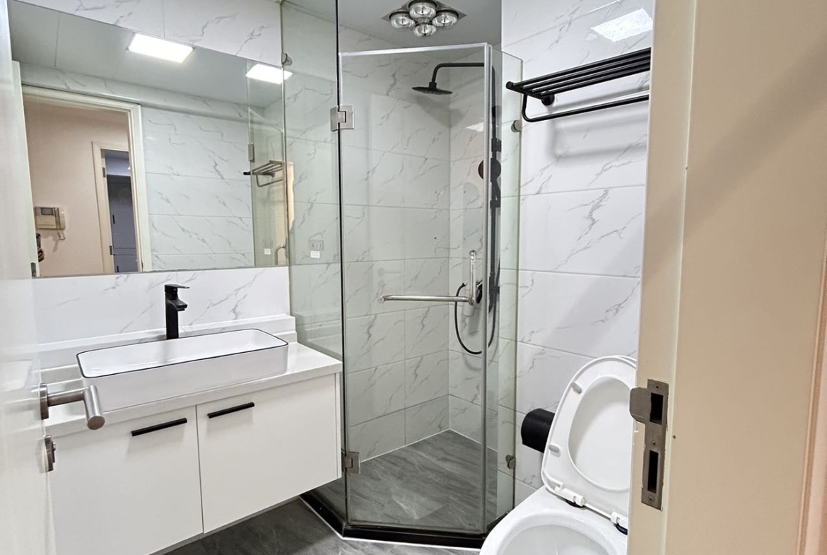 2-bed, 2-bath unit at One Park Avenue in Jing'an. 110 sqm, underfloor heating, central AC, oven, dishwasher. 50% greenery, clubhouse. 22,600 RMB/month.