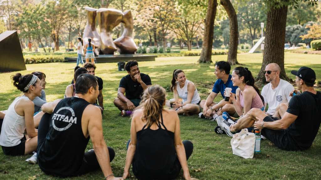 A diverse group of expats and locals gathering for a community workout in Jing'an Sculpture Park, representing Shanghai's active expat social scene.


