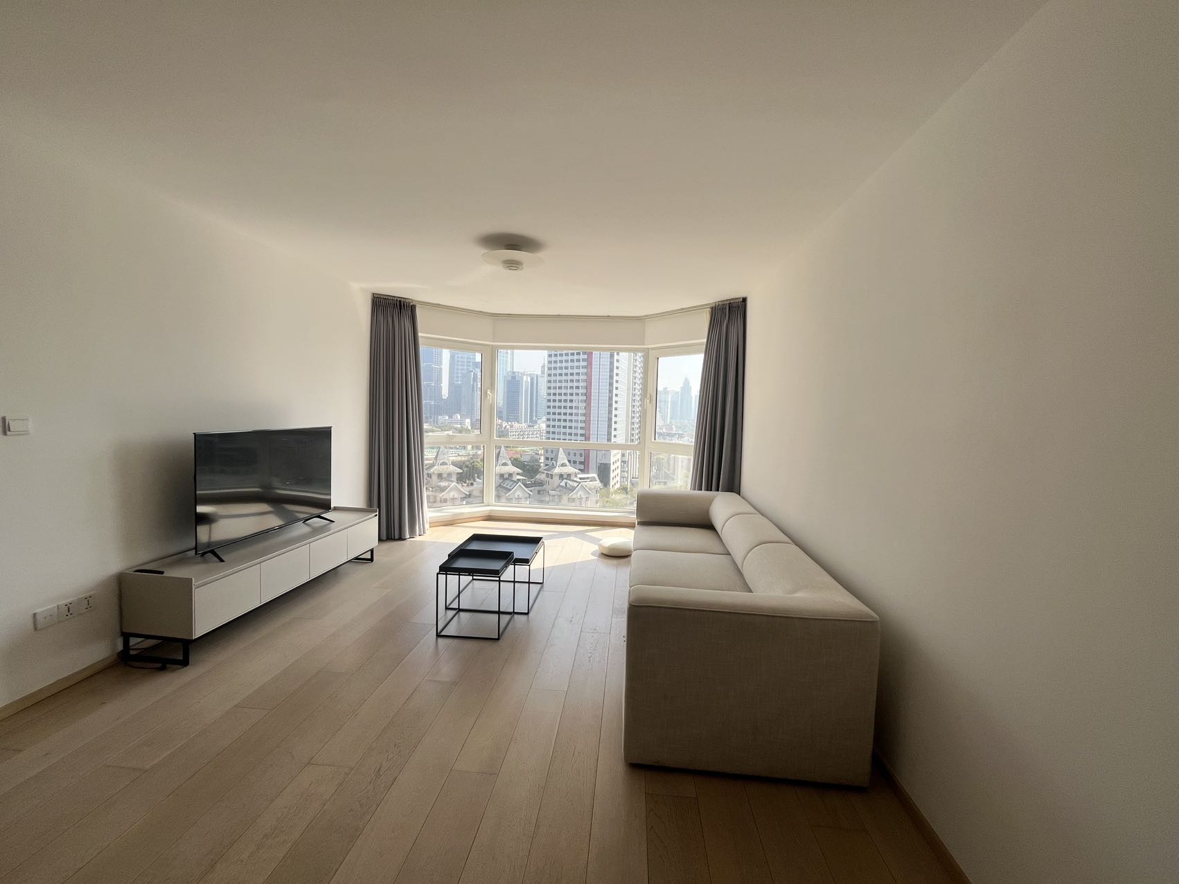 2-bed, 2-bath unit at Shanghai Grand Plaza on Julu Road. 114 sqm, underfloor heating, central AC, clubhouse with pool. 25,000 RMB/month.