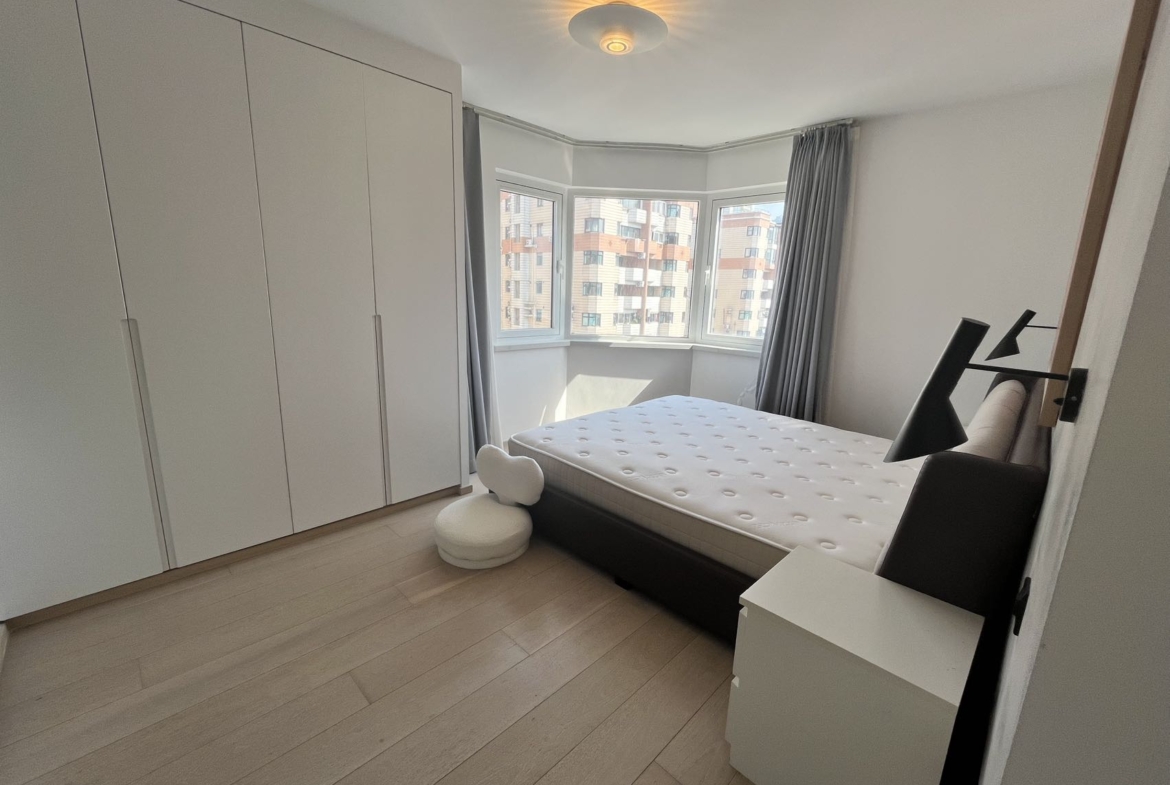 2-bed, 2-bath unit at Shanghai Grand Plaza on Julu Road. 114 sqm, underfloor heating, central AC, clubhouse with pool. 25,000 RMB/month.