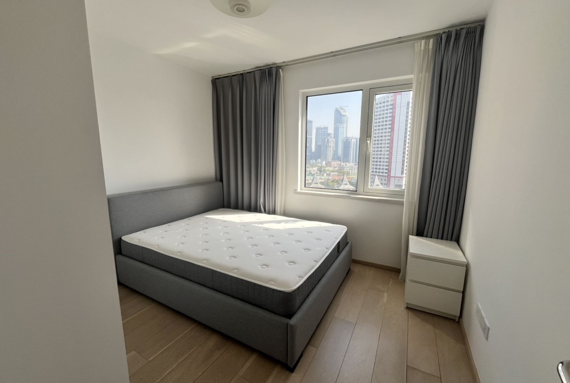 2-bed, 2-bath unit at Shanghai Grand Plaza on Julu Road. 114 sqm, underfloor heating, central AC, clubhouse with pool. 25,000 RMB/month.