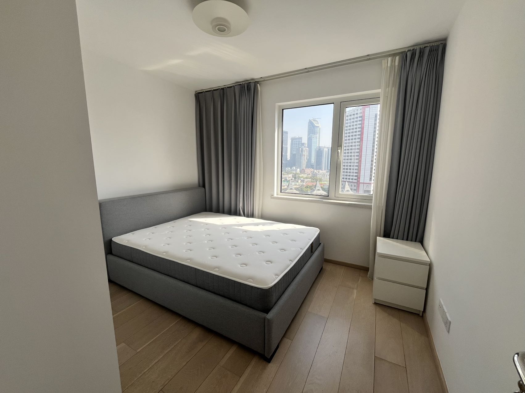 2-bed, 2-bath unit at Shanghai Grand Plaza on Julu Road. 114 sqm, underfloor heating, central AC, clubhouse with pool. 25,000 RMB/month.