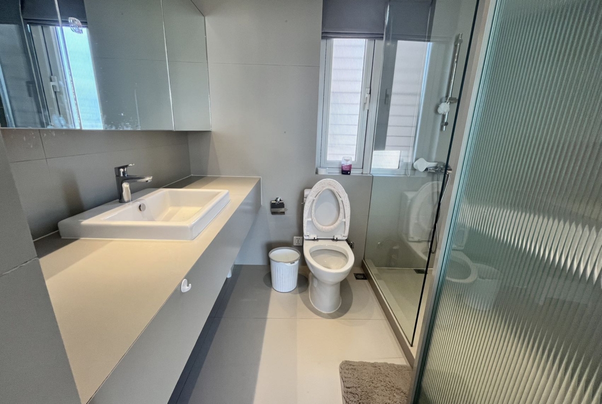 2-bed, 2-bath unit at Shanghai Grand Plaza on Julu Road. 114 sqm, underfloor heating, central AC, clubhouse with pool. 25,000 RMB/month.
