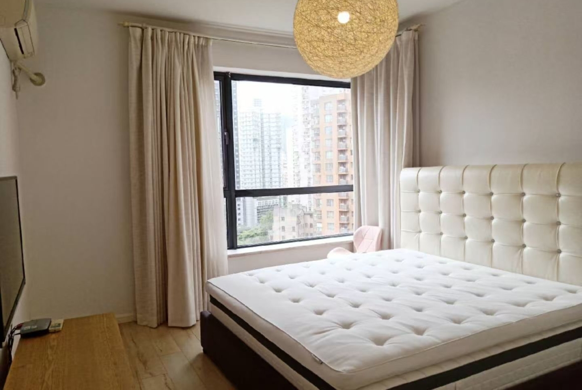 2-bed, 2-living, 1-bath unit at Territory Shanghai. 118 sqm, south-facing balcony, central Jing'an location near Nanjing West Road. 19,000 RMB/month.