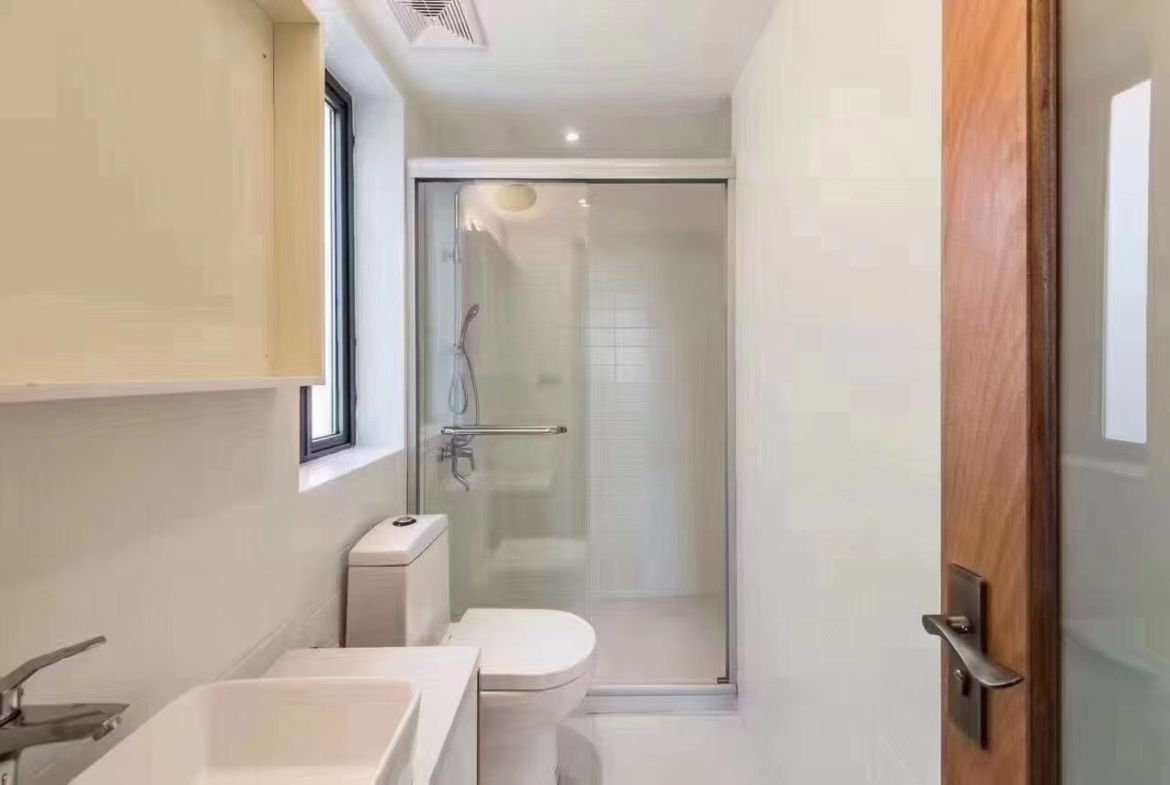 2-bed, 2-bath unit on Huaihai Middle Road near Changshu Road. 120 sqm, 10 sqm balcony, underfloor heating, central AC. Steps from Lines 1, 7, and 10. 13,500 RMB/month.